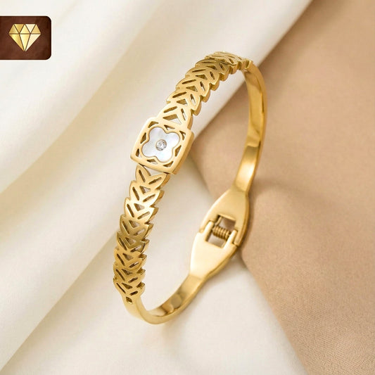 Gold-plated Kada bracelet with cut-out leaf motifs and mother-of-pearl clover centerpiece with cubic zirconia – Monica’s Jewel Studio